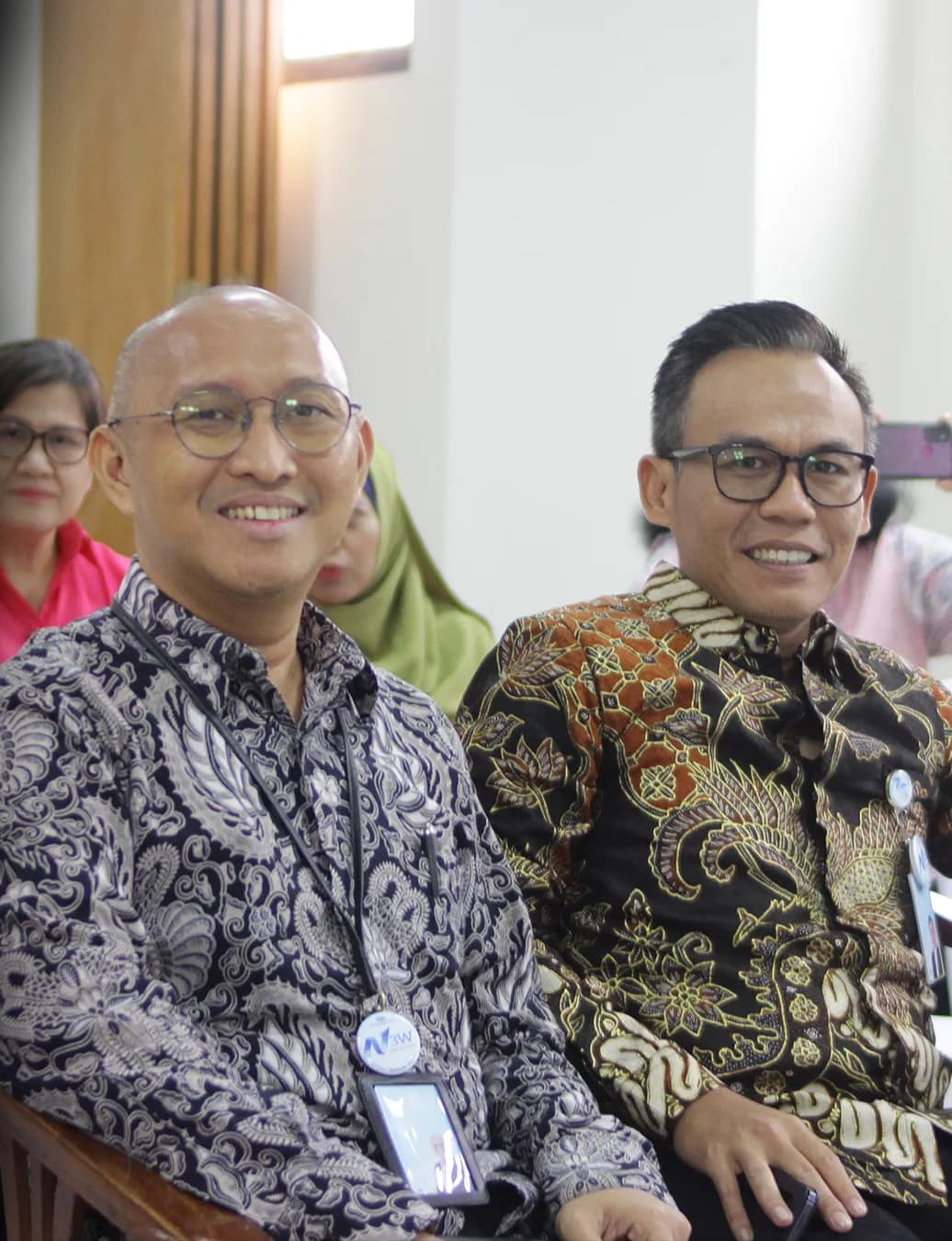 Dua pimpinan berbatik tersenyum di barisan tamu undangan